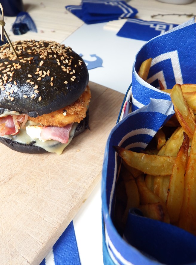Burger breton recette terre et mer avec des buns à l'encre de sèche, lard, poisson pané, et mayonnaise façon sauce au beurre blanc