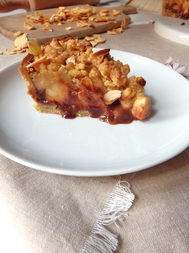 Crumble aux pommes et au chocolat dans une pâte sablée aux spéculoos avec des fleurs de pensées